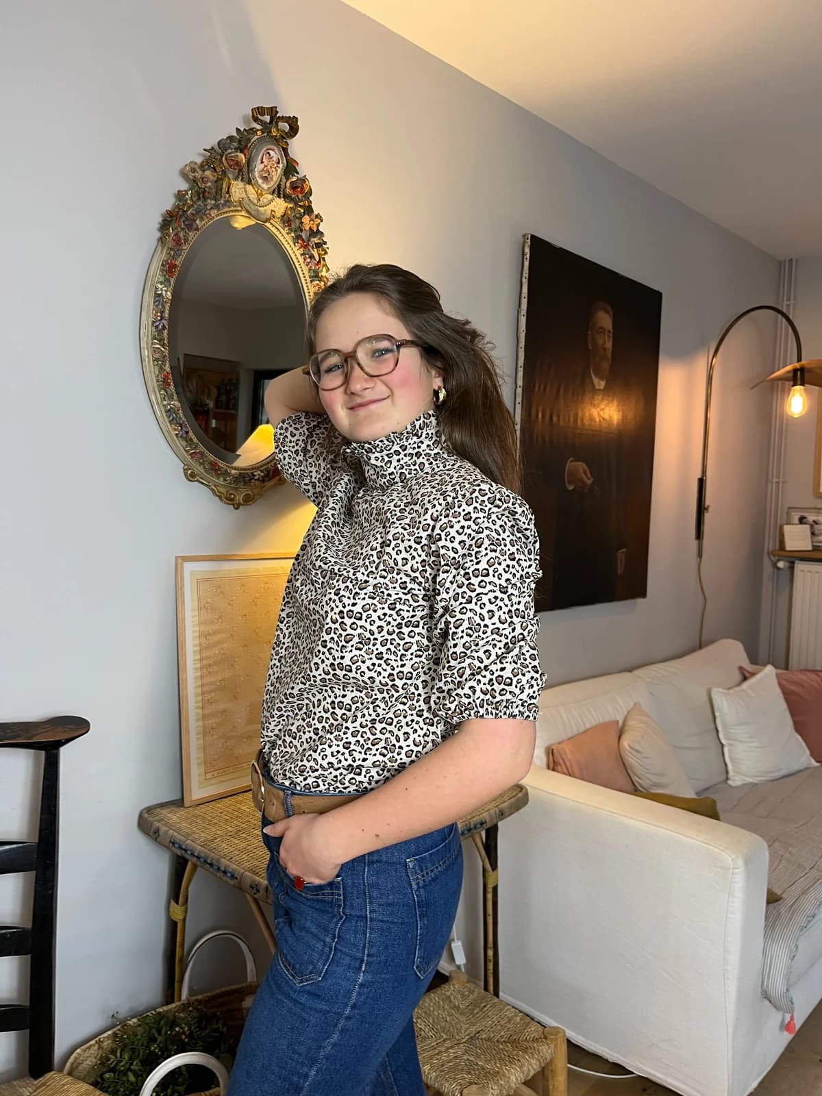 Jeune femme souriante en blouse léopard col cheminée, décor intérieur rétro — By Mésange