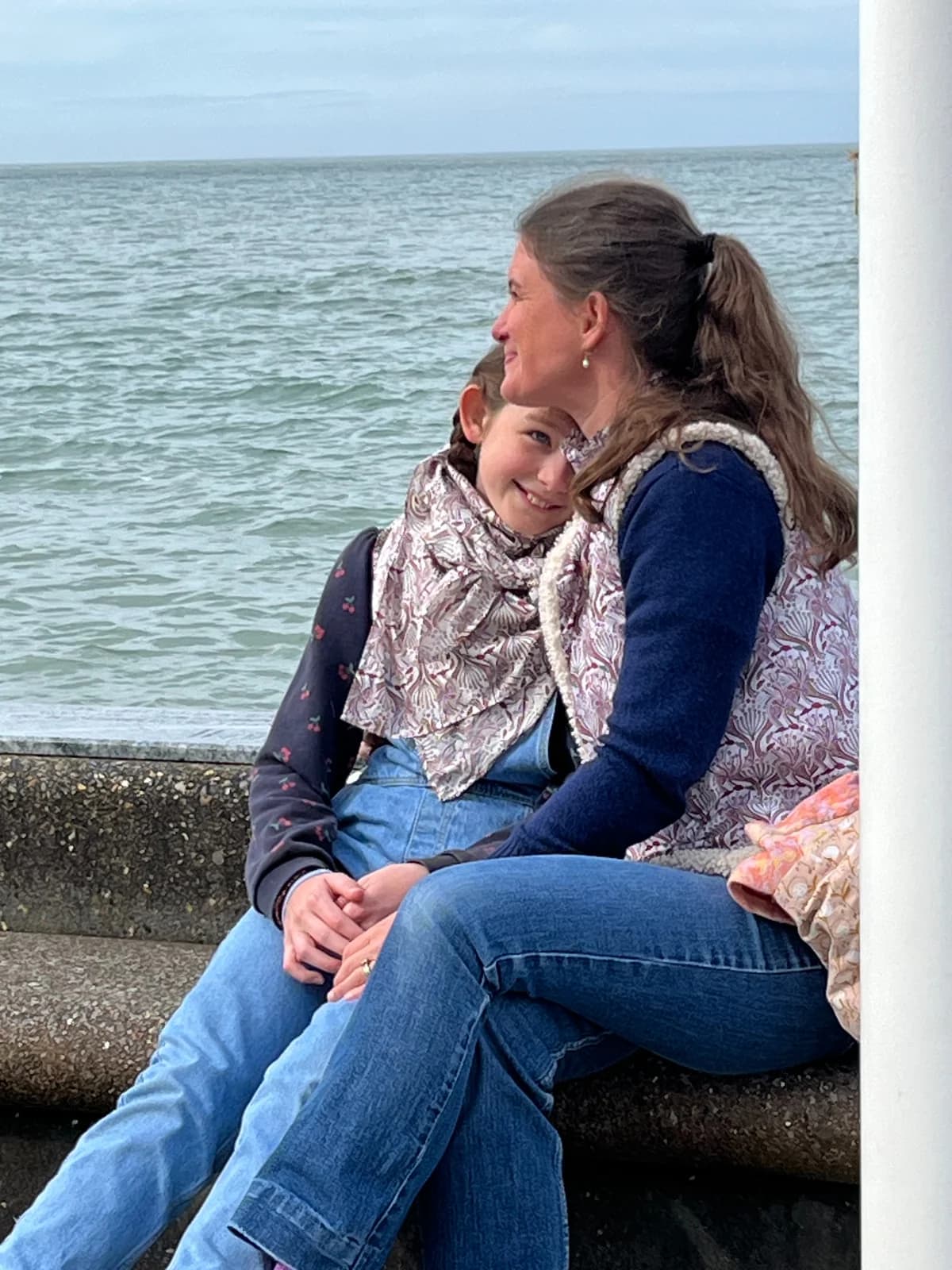 Stéphanie et sa fille de profil au bord de mer, blouse paon et écharpe fleurie — By Mésange