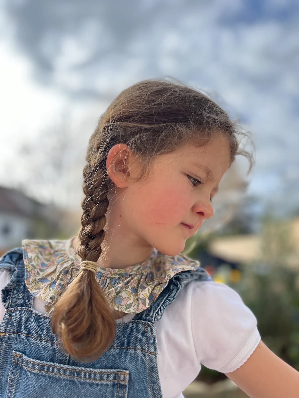 Petite fille en plein air, col claudine fleuri et salopette en jean — By Mésange