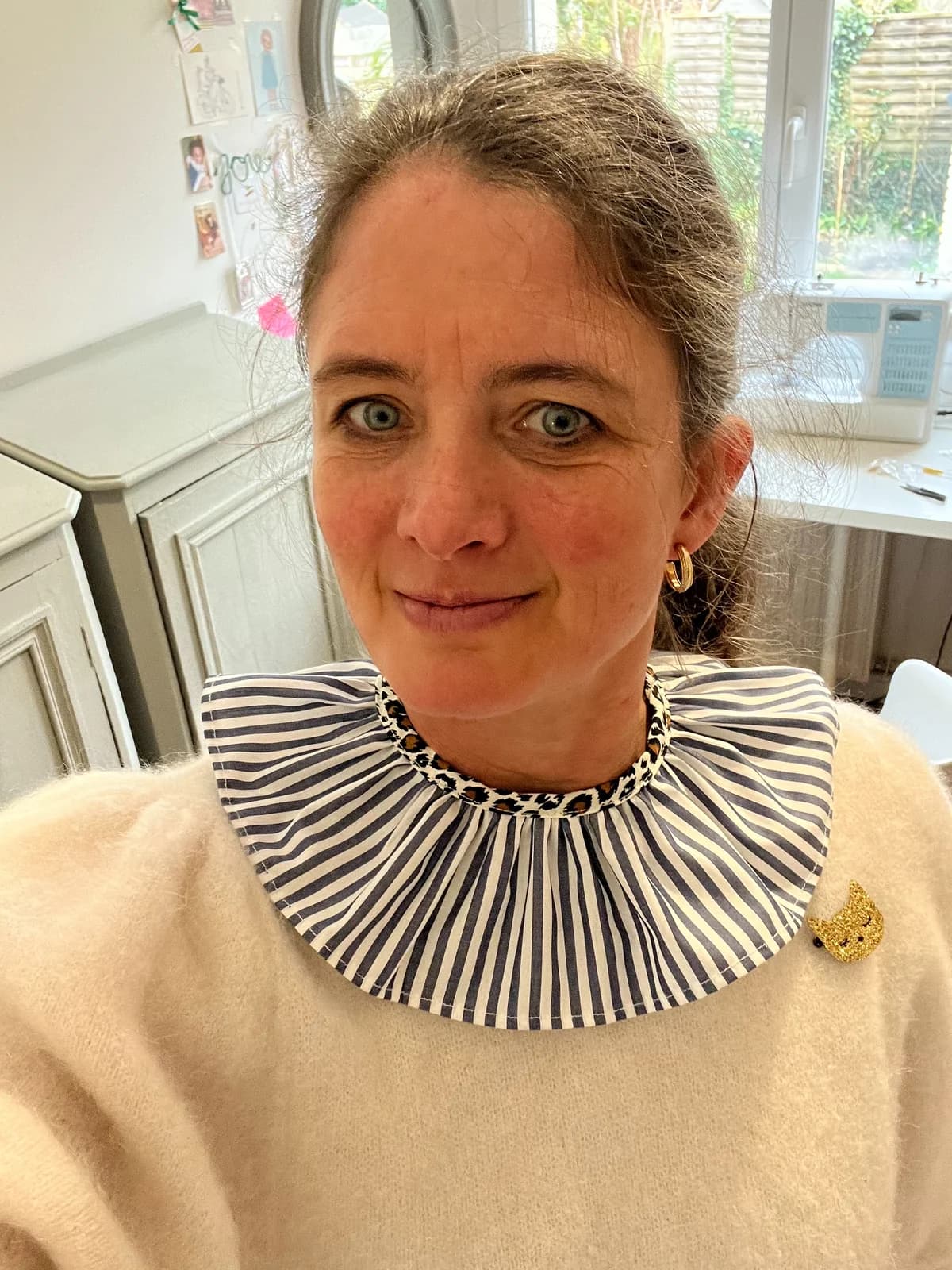 Stéphanie By Mésange portant un col claudine rayé bleu marine et blanc avec broche dorée