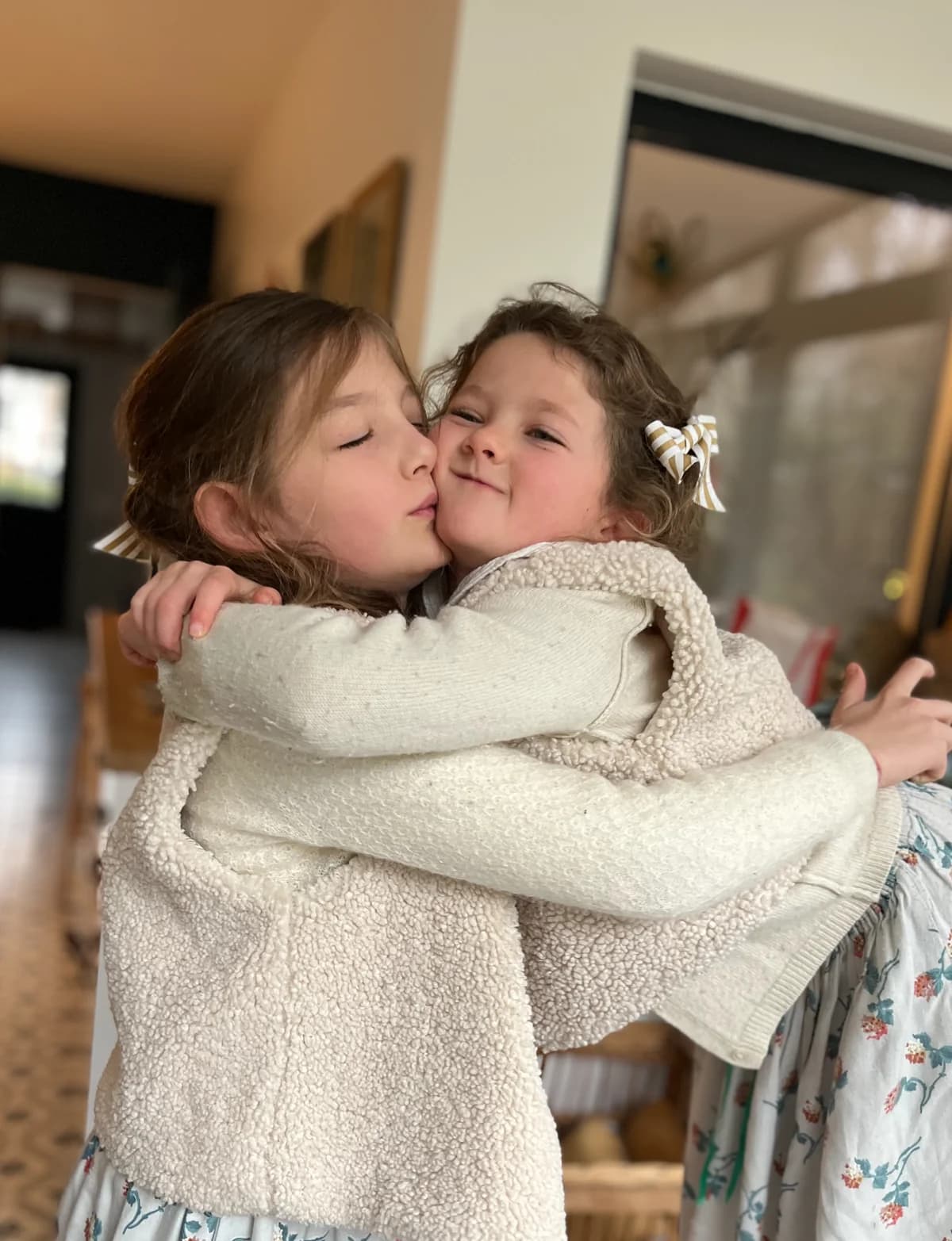 Deux sœurs s'embrassant en gilets berger ivoire — vêtements enfant By Mésange