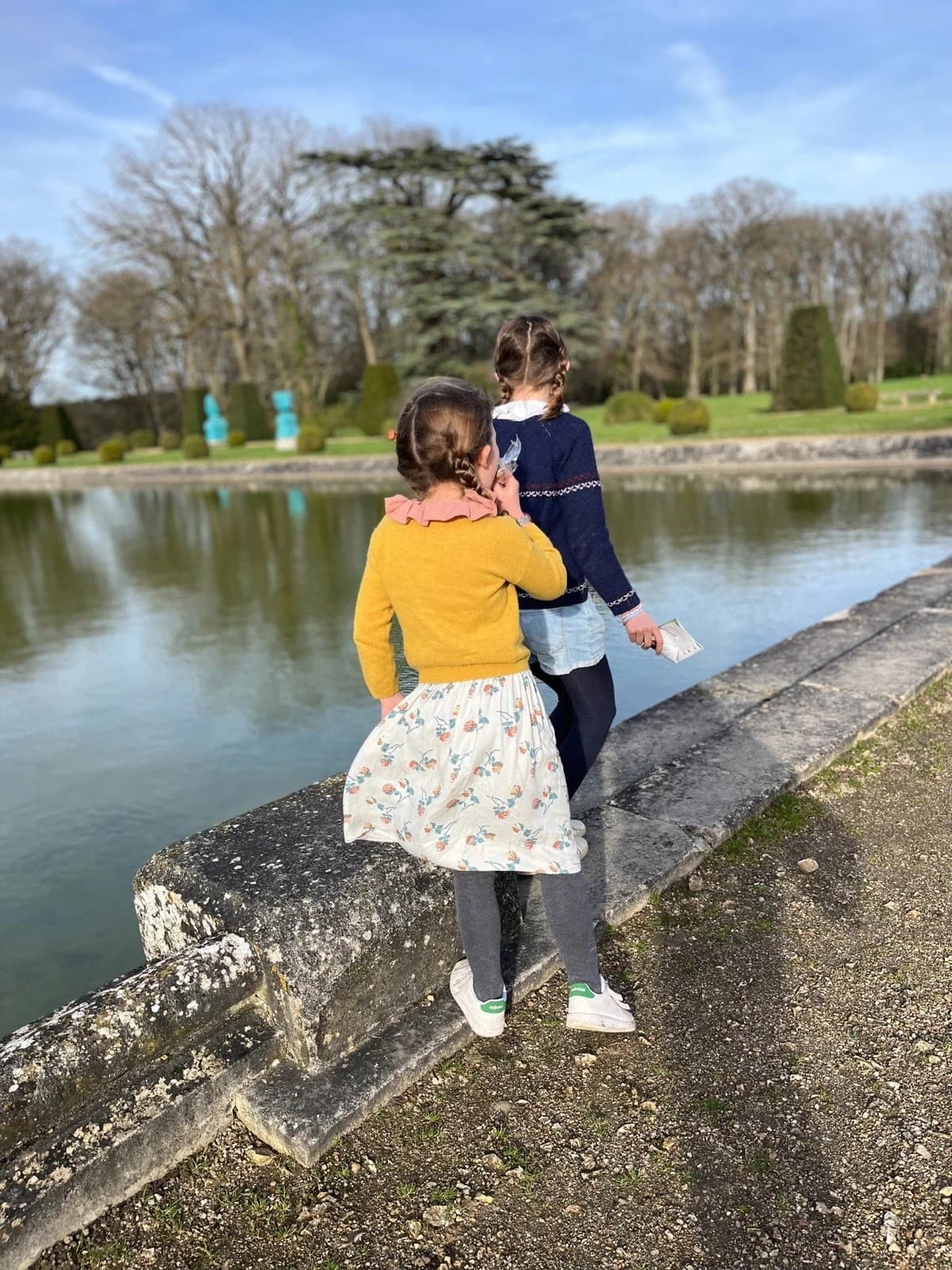 Deux fillettes en vêtements By Mésange au bord d'un bassin du château de Versailles
