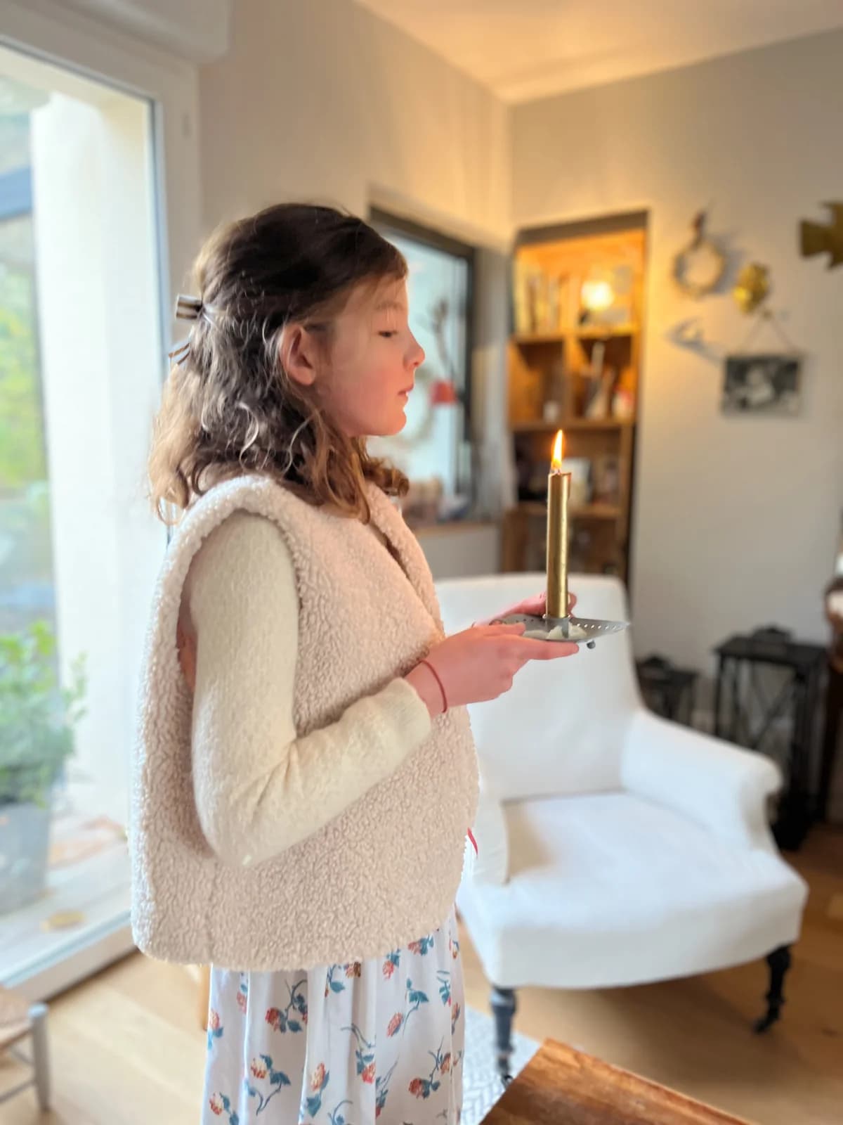 Fillette en gilet berger ivoire tenant une bougie, jupe fleurie — By Mésange