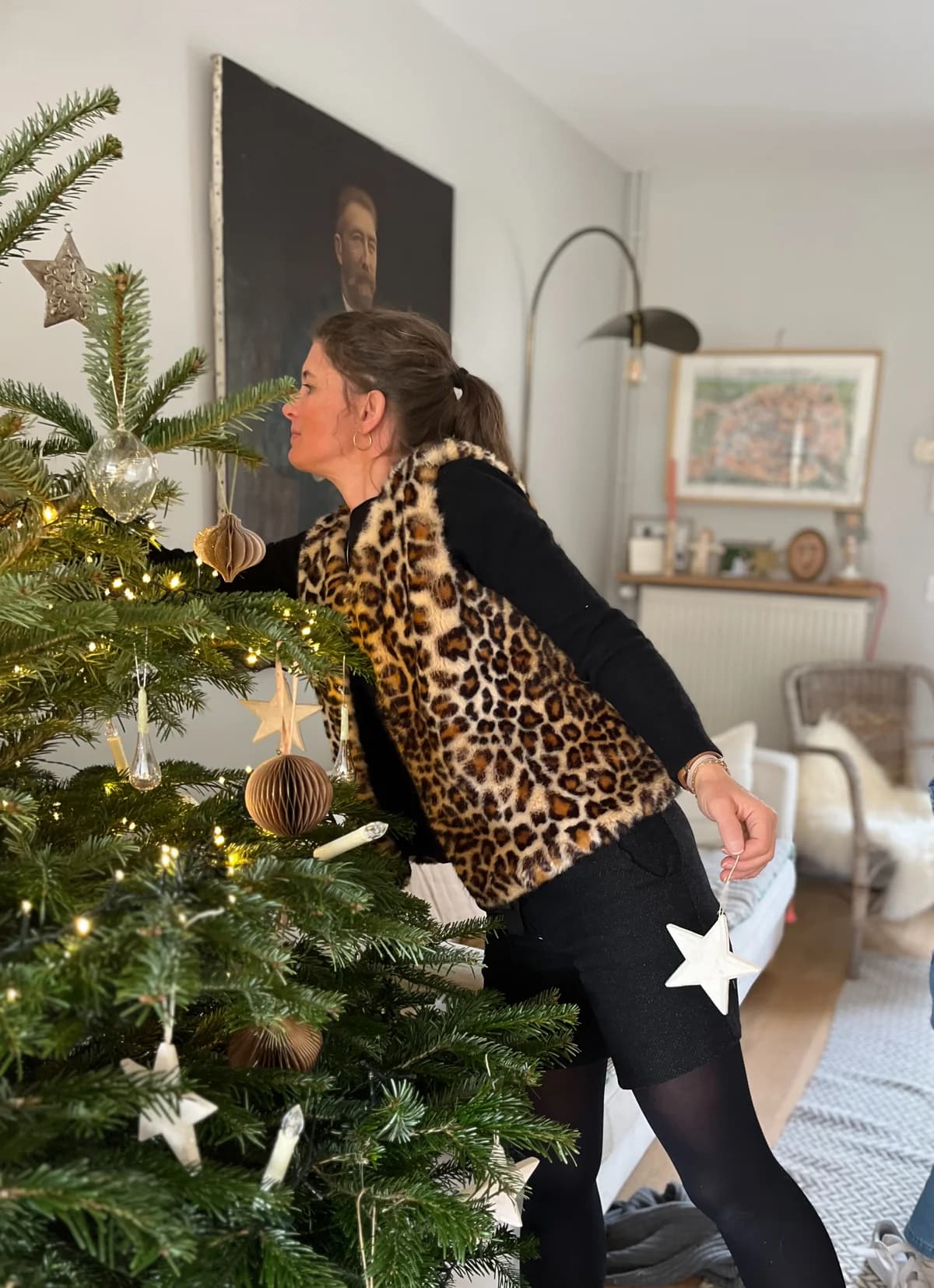 Femme en manteau léopard fait main By Mésange décorant le sapin de Noël